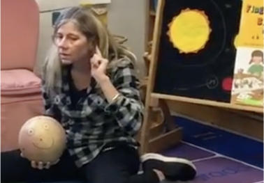 Woman holding ball signalling to listen