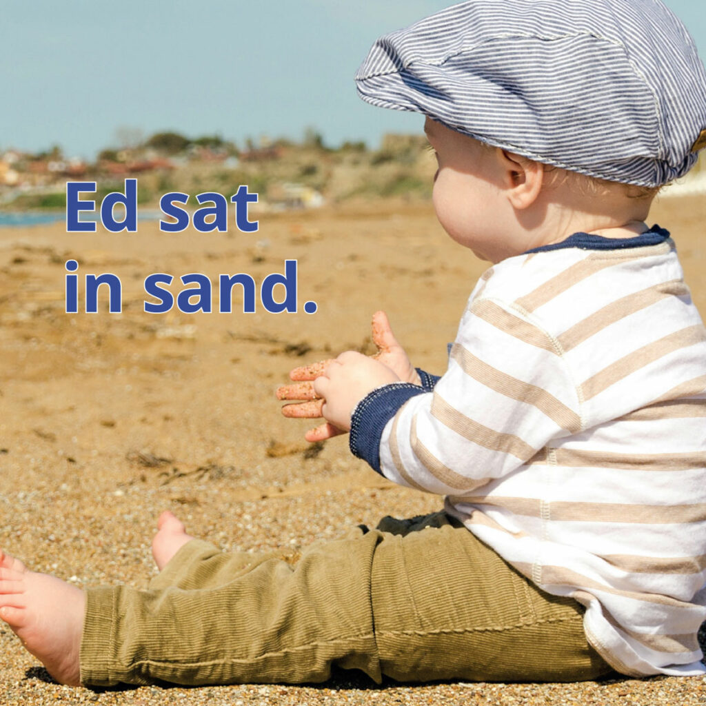 Sand reader image of young child wearing hat sitting on the beach