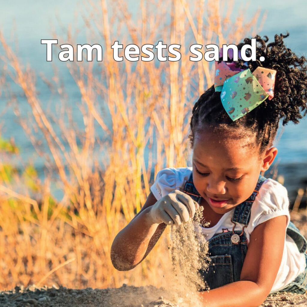 Sand reader image of child sifting sand in front of tall grass