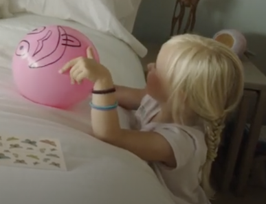 Child playing with pink ball learning letter sounds