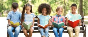 Happy Children Reading on a Park Bench